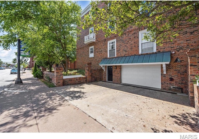 10 Jefferson Rd Unit 3A, Webster Groves, MO 63119 - view of front of property featuring driveway, brick siding, an attached garage, and a standing seam roof