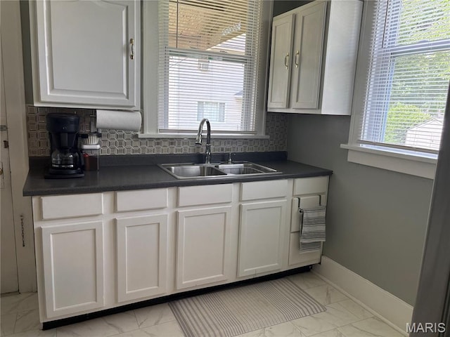 2425 State St, Granite City, IL 62040 - kitchen featuring light marble finish flooring, dark countertops, white cabinets, and tasteful backsplash