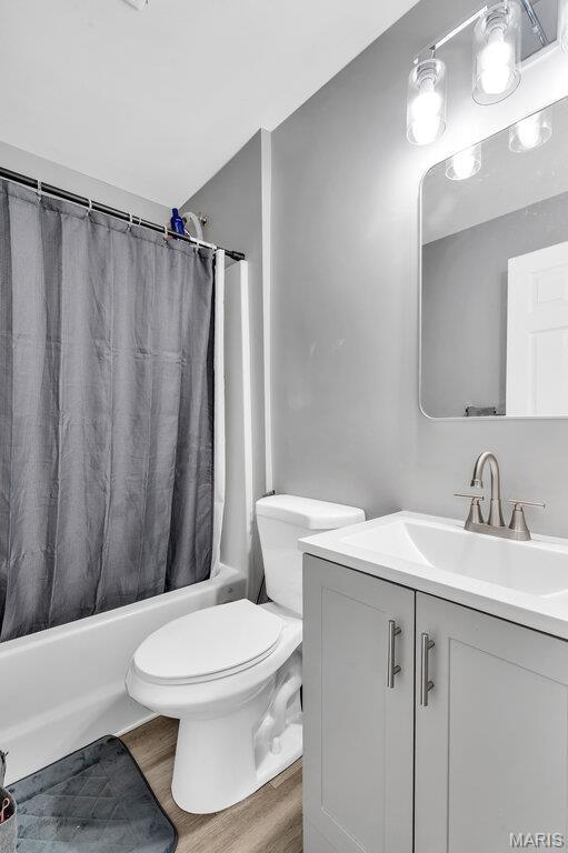 3711 Ashby Rd, Saint Ann, MO 63074 - bathroom featuring vanity, shower / bathtub combination with curtain, and wood finished floors