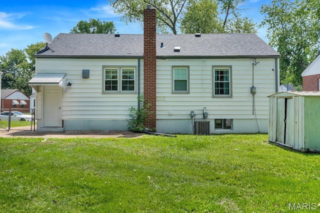 3711 Ashby Rd, Saint Ann, MO 63074 - rear view of house with a storage unit, a chimney, and a shingled roof