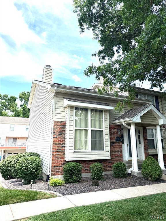 1729 Honeysuckle Dr, Saint Charles, MO 63303 - view of front of home with a chimney and brick siding