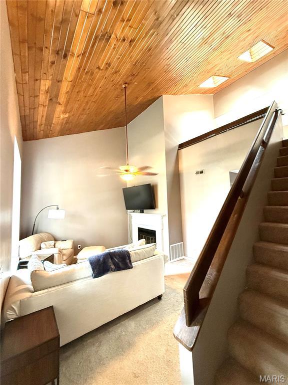 1729 Honeysuckle Dr, Saint Charles, MO 63303 - living room featuring stairway, a ceiling fan, wooden ceiling, a glass covered fireplace, and vaulted ceiling
