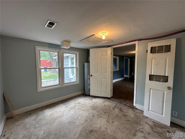 1506 S Gertrude St, Salem, MO 65560 - unfurnished bedroom featuring attic access, water heater, unfinished concrete flooring, and a textured ceiling
