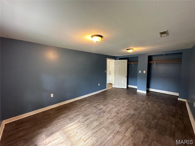 1506 S Gertrude St, Salem, MO 65560 - unfurnished bedroom featuring multiple closets, dark wood-style floors, and a textured ceiling
