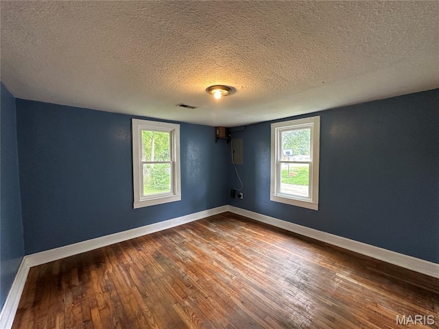 1506 S Gertrude St, Salem, MO 65560 - spare room featuring dark wood-style flooring, a textured ceiling, and plenty of natural light