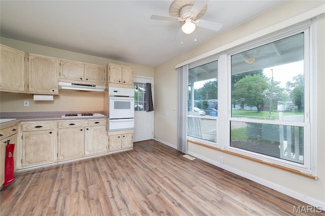 1340 Central Pkwy, Florissant, MO 63031 - kitchen featuring white oven, a warming drawer, under cabinet range hood, light wood-style flooring, and a ceiling fan