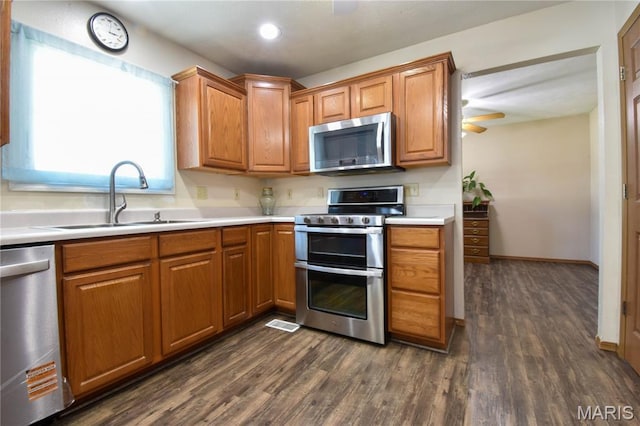 408 Marty Graten Ct, Hamel, IL 62046 - kitchen with appliances with stainless steel finishes, dark wood-style flooring, light countertops, brown cabinetry, and recessed lighting