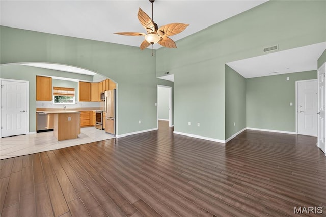 5 Monarch Trace Ct Unit 305, Chesterfield, MO 63017 - unfurnished living room featuring light wood-type flooring, arched walkways, and a ceiling fan