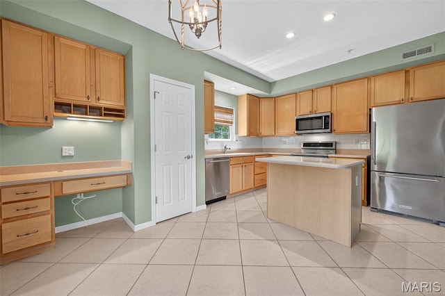 5 Monarch Trace Ct Unit 305, Chesterfield, MO 63017 - kitchen with stainless steel appliances, light countertops, a kitchen island, backsplash, and built in desk