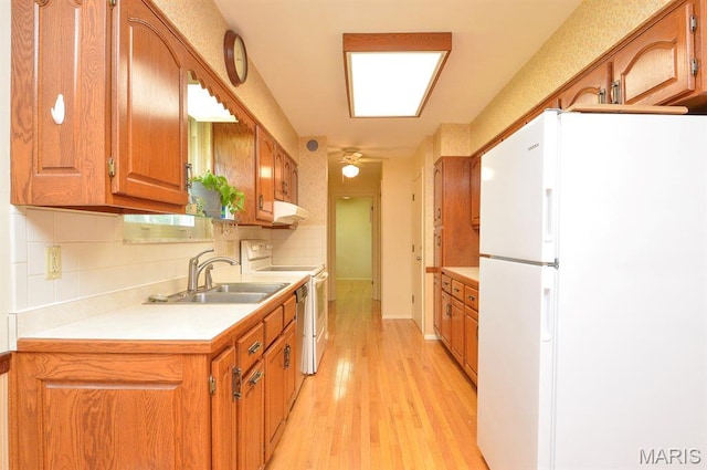 318 W Oak St, Mascoutah, IL 62258 - kitchen with white appliances, light countertops, light wood-style floors, brown cabinets, and backsplash