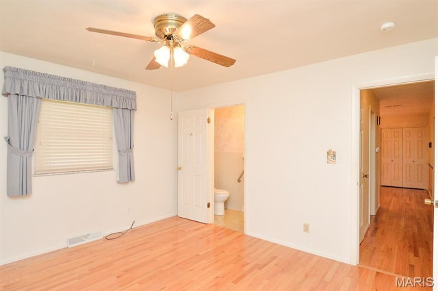 318 W Oak St, Mascoutah, IL 62258 - unfurnished bedroom with wood finished floors, connected bathroom, and a ceiling fan