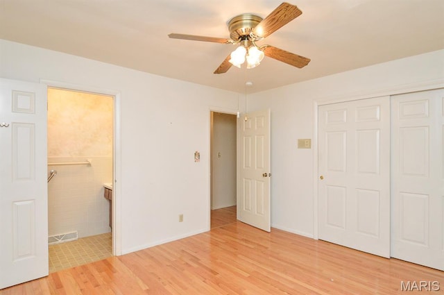 318 W Oak St, Mascoutah, IL 62258 - unfurnished bedroom with light wood-type flooring, a closet, ensuite bath, and ceiling fan