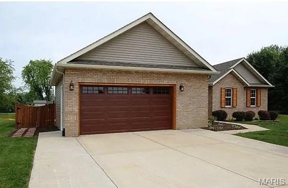 2763 Cascade Lake Dr, Belleville, IL 62221 - view of front facade with brick siding, an attached garage, driveway, and a front lawn