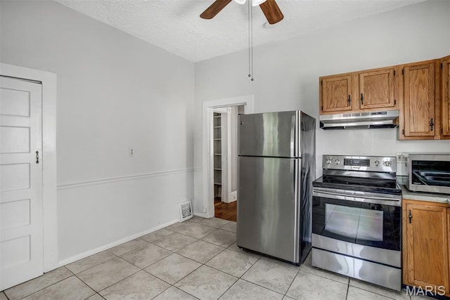 2617 Sutton Blvd, Maplewood, MO 63143 - kitchen with stainless steel appliances, under cabinet range hood, a ceiling fan, brown cabinetry, and a textured ceiling