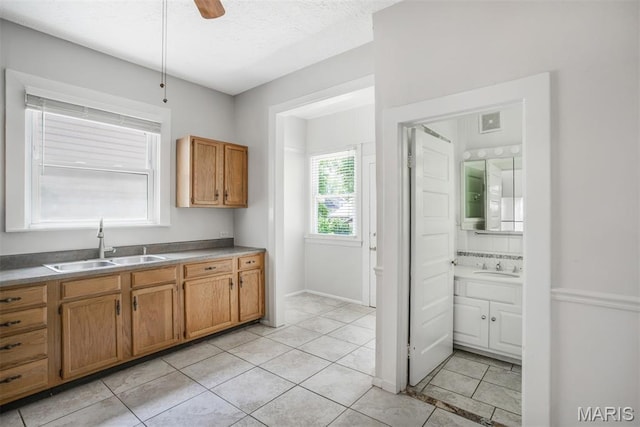 2617 Sutton Blvd, Maplewood, MO 63143 - kitchen with light tile patterned floors, brown cabinetry, ceiling fan, and a textured ceiling