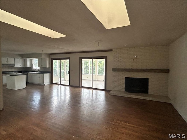 17300 W Bridle Trl, Wildwood, MO 63038 - unfurnished living room with a skylight, plenty of natural light, and dark wood-style floors