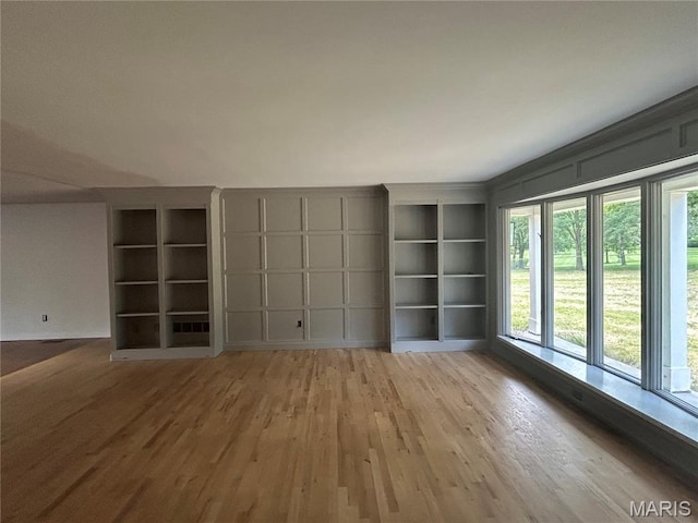 17300 W Bridle Trl, Wildwood, MO 63038 - spare room featuring wood finished floors, built in shelves, and a decorative wall