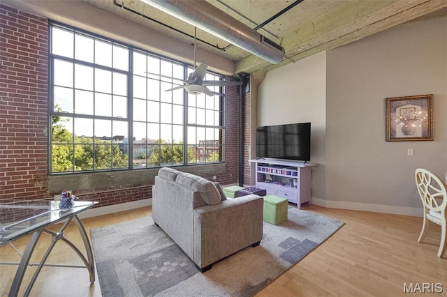 4100 Forest Park Ave Unit 306, Saint Louis, MO 63108 - living area featuring wood finished floors, brick wall, and ceiling fan