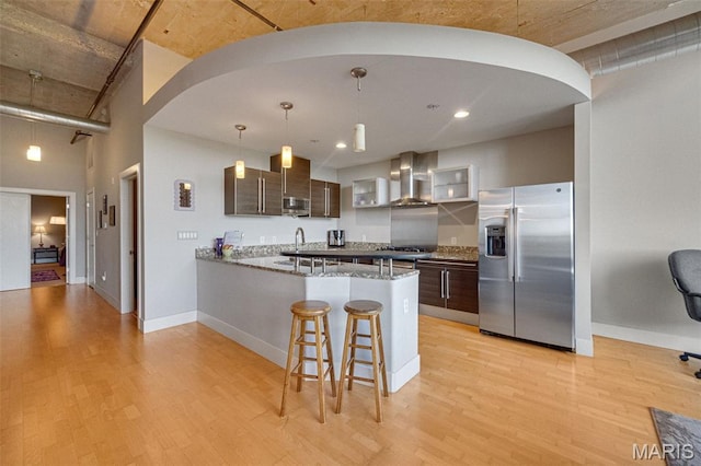 4100 Forest Park Ave Unit 306, Saint Louis, MO 63108 - kitchen featuring stainless steel appliances, wall chimney exhaust hood, light wood finished floors, a peninsula, and recessed lighting