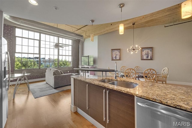 4100 Forest Park Ave Unit 306, Saint Louis, MO 63108 - kitchen featuring appliances with stainless steel finishes, light wood-style flooring, pendant lighting, and light stone counters