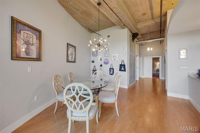 4100 Forest Park Ave Unit 306, Saint Louis, MO 63108 - dining room with light wood finished floors, a chandelier, beamed ceiling, and a towering ceiling