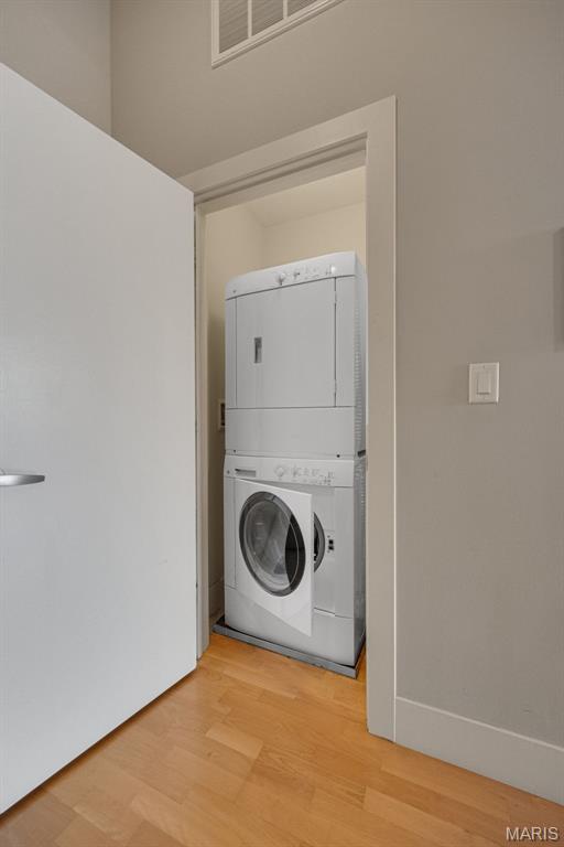 4100 Forest Park Ave Unit 306, Saint Louis, MO 63108 - washroom with stacked washer / drying machine and light wood-style floors