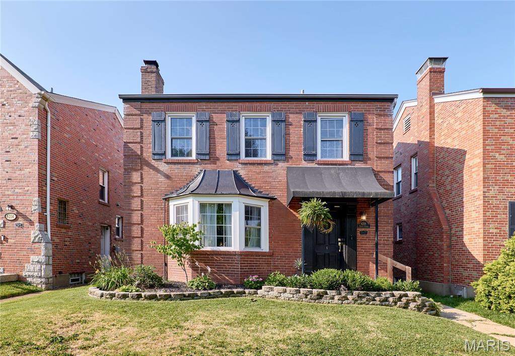 6218 Pernod Ave, Saint Louis, MO 63139 - view of front of home with a front lawn, brick siding, and a chimney