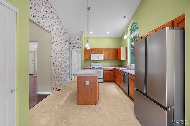 1473 Crooked Stick Dr, Ofallon, MO 63366 - kitchen featuring stainless steel appliances, wallpapered walls, a kitchen island, light countertops, and decorative light fixtures