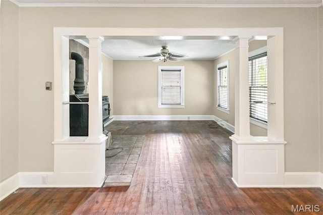 86 Mill St, Elsah, IL 62028 - spare room with a wood stove, hardwood / wood-style flooring, decorative columns, a ceiling fan, and ornamental molding