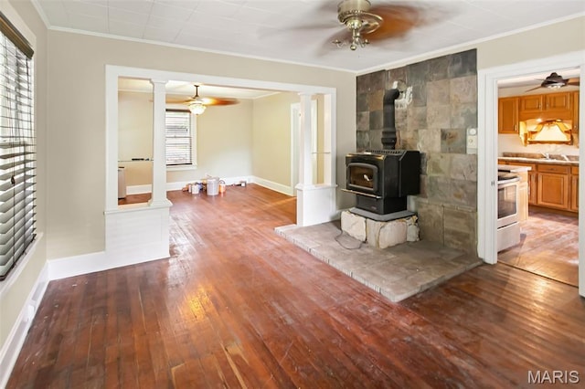 86 Mill St, Elsah, IL 62028 - unfurnished living room with a ceiling fan, ornate columns, ornamental molding, hardwood / wood-style flooring, and a wood stove