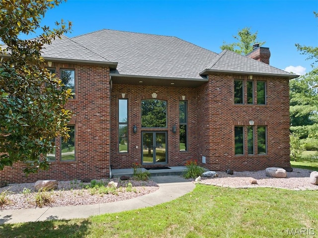 517 E Waters Edge Dr, Shiloh, IL 62221 - view of front of house with a chimney, brick siding, a front yard, and roof with shingles