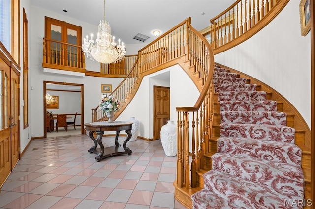 517 E Waters Edge Dr, Shiloh, IL 62221 - foyer featuring stairs, a chandelier, tile patterned floors, and a towering ceiling