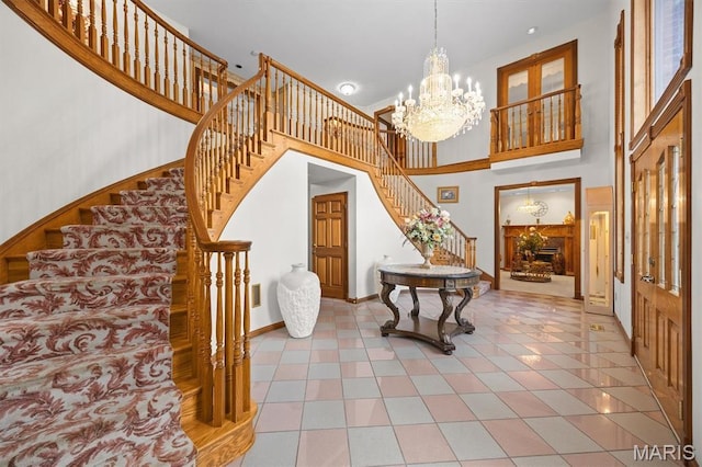 517 E Waters Edge Dr, Shiloh, IL 62221 - foyer entrance featuring stairway, a high ceiling, a chandelier, and light tile patterned flooring