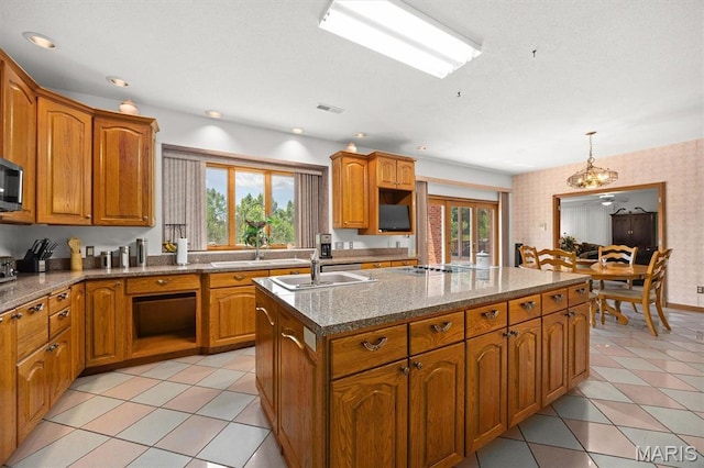 517 E Waters Edge Dr, Shiloh, IL 62221 - kitchen with an island with sink, brown cabinets, and stone counters