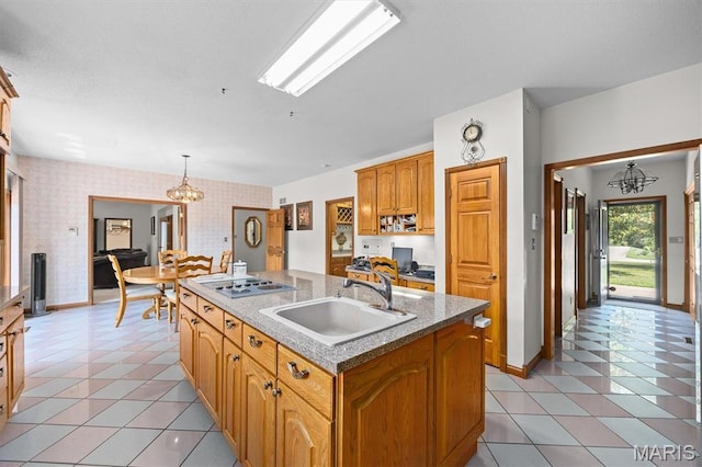 517 E Waters Edge Dr, Shiloh, IL 62221 - kitchen with electric stovetop, an island with sink, wallpapered walls, light tile patterned floors, and a chandelier