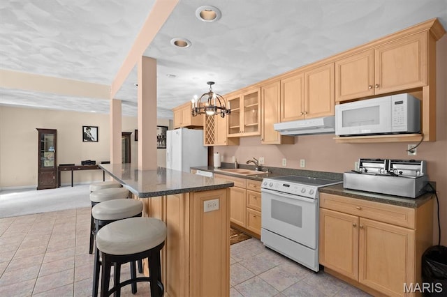 517 E Waters Edge Dr, Shiloh, IL 62221 - kitchen with white appliances, under cabinet range hood, light brown cabinetry, a breakfast bar area, and a chandelier