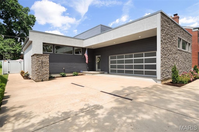 5951 Jamieson Ave, Saint Louis, MO 63109 - contemporary home with a garage, driveway, a gate, and stone siding