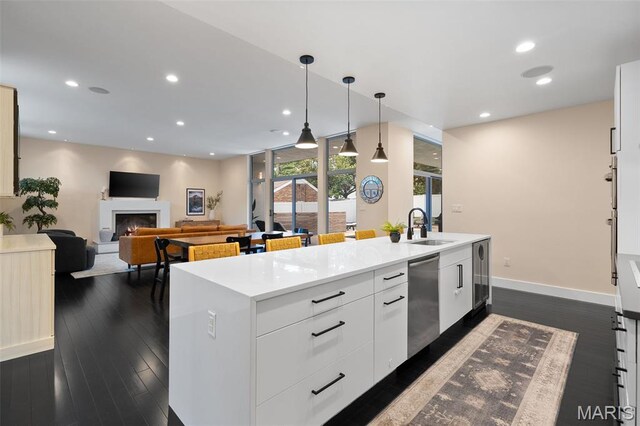 5951 Jamieson Ave, Saint Louis, MO 63109 - kitchen featuring stainless steel dishwasher, a center island with sink, light countertops, a warm lit fireplace, and wine cooler
