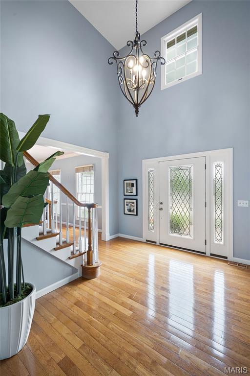 17527 Adams Way Ct, Wildwood, MO 63005 - foyer entrance with a high ceiling, a chandelier, stairs, and wood finished floors