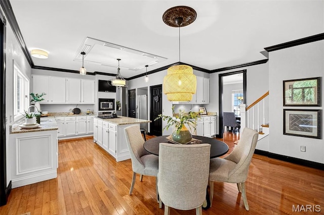 17527 Adams Way Ct, Wildwood, MO 63005 - dining room featuring crown molding, light wood-type flooring, and stairs