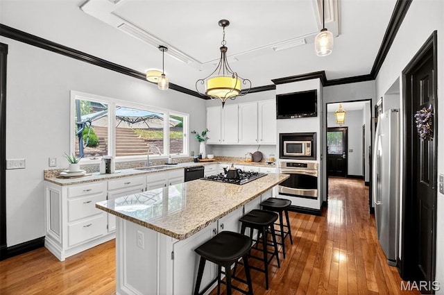 17527 Adams Way Ct, Wildwood, MO 63005 - kitchen featuring stainless steel appliances, a kitchen island, light wood-type flooring, white cabinets, and ornamental molding