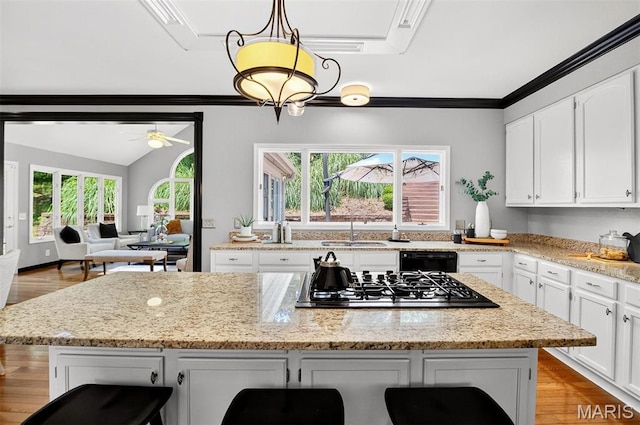 17527 Adams Way Ct, Wildwood, MO 63005 - kitchen featuring stainless steel gas stovetop, dishwasher, white cabinets, a breakfast bar area, and ornamental molding