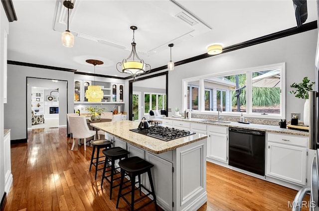 17527 Adams Way Ct, Wildwood, MO 63005 - kitchen with black dishwasher, gas cooktop, a kitchen island, crown molding, and a kitchen breakfast bar