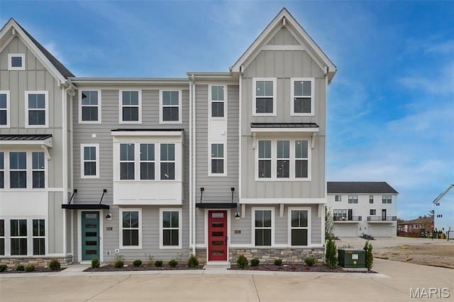 8935 E Gateway Hts Unit 94-808, Richmond Heights, MO 63144 - townhome / multi-family property with board and batten siding, stone siding, and a standing seam roof