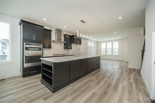 8935 E Gateway Hts Unit 94-808, Richmond Heights, MO 63144 - kitchen with wall chimney range hood, a large island, light countertops, open shelves, and light wood-type flooring