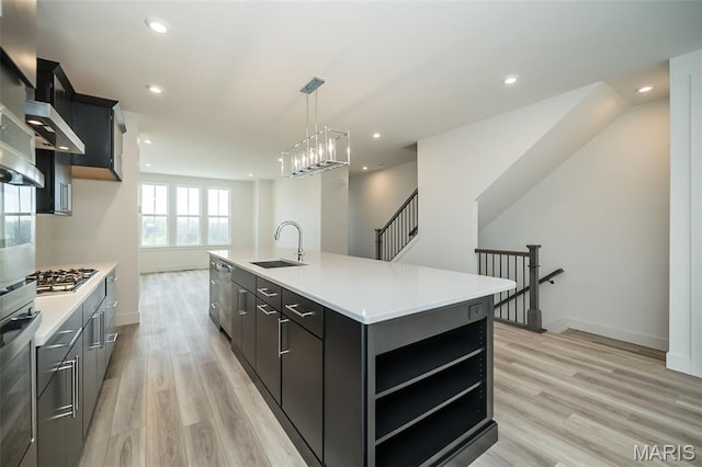 8935 E Gateway Hts Unit 94-808, Richmond Heights, MO 63144 - kitchen featuring stainless steel appliances, light countertops, light wood finished floors, open shelves, and a kitchen island with sink