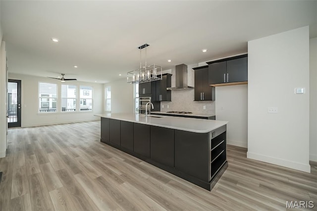 8935 E Gateway Hts Unit 94-808, Richmond Heights, MO 63144 - kitchen with wall chimney exhaust hood, light countertops, light wood-type flooring, an island with sink, and recessed lighting