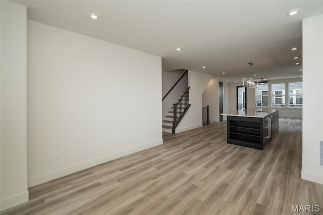 8935 E Gateway Hts Unit 94-808, Richmond Heights, MO 63144 - unfurnished living room with light wood-type flooring, stairway, recessed lighting, and a chandelier
