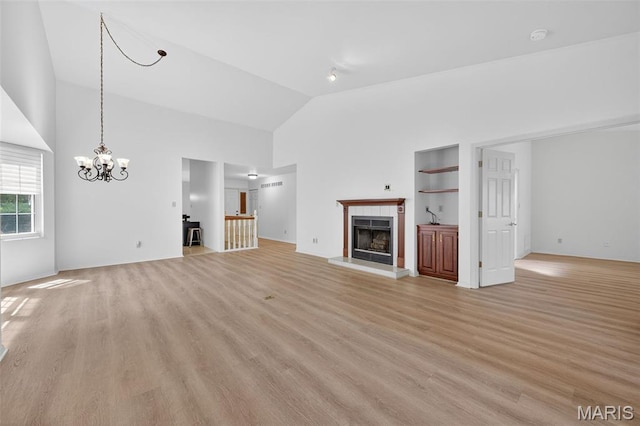 425 Charter Way Dr, Wildwood, MO 63040 - unfurnished living room with a tile fireplace, light wood-style floors, a chandelier, high vaulted ceiling, and built in shelves