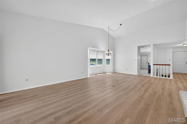 425 Charter Way Dr, Wildwood, MO 63040 - unfurnished living room with light wood-style flooring, a chandelier, and high vaulted ceiling
